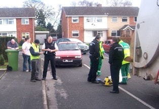 Police question witnesses after a Biffa operative was clipped by a passing car